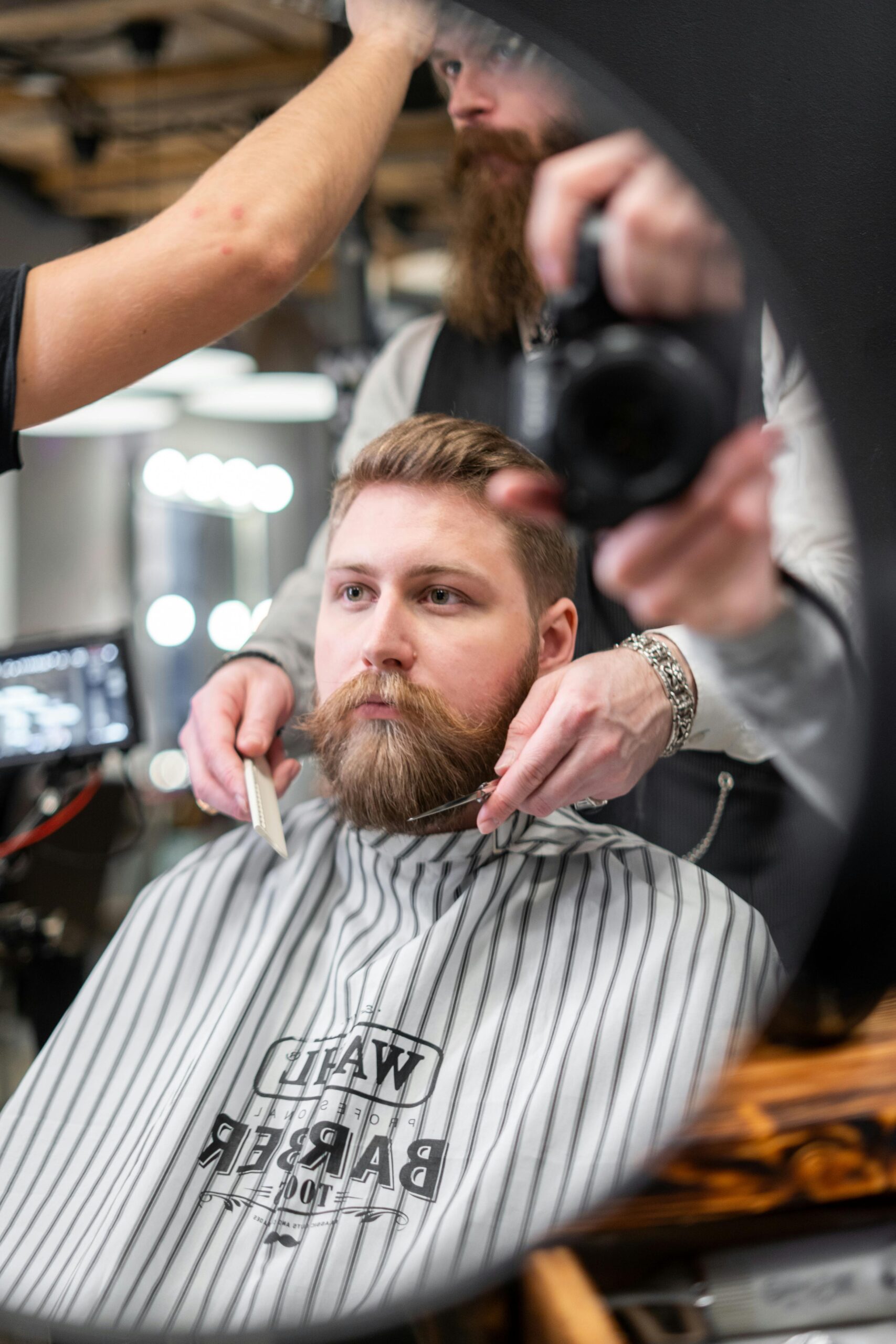 Beard grooming kit essentials with scissors, comb, and oil on a wooden surface