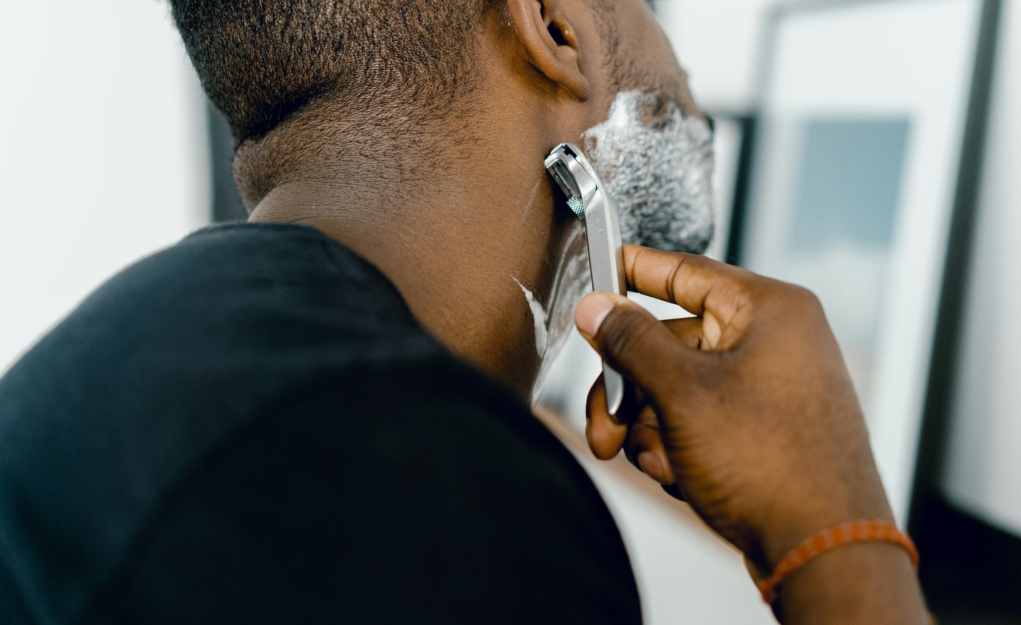 A table displaying essential beard grooming tools: trimmer, brush, comb, oil, balm, scissors.