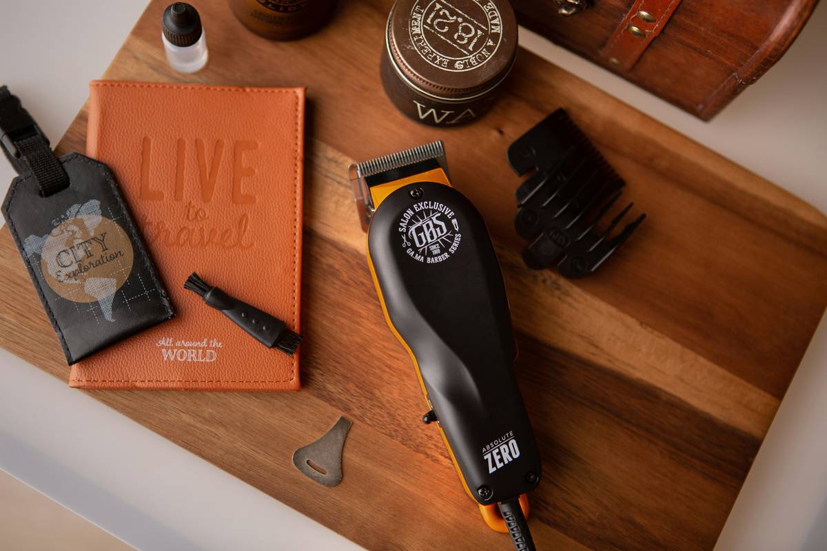 A premium beard grooming kit containing scissors, comb, oil, balm, and brush laid out on a wooden table